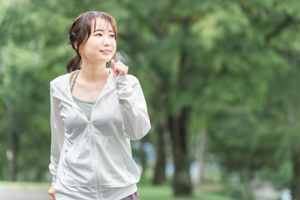 長袖パーカーを着てウォーキングする女性