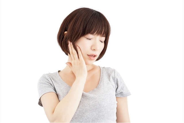あごに痛みを感じている女性